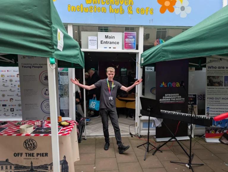 A young man welcoming visitors at the entrance of the Whitehaven Inclusion Hub and Cafe